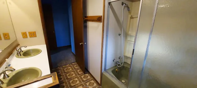 a bathroom with a sink a mirror and a shower