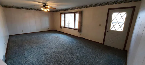 a view of a livingroom with a ceiling fan and window