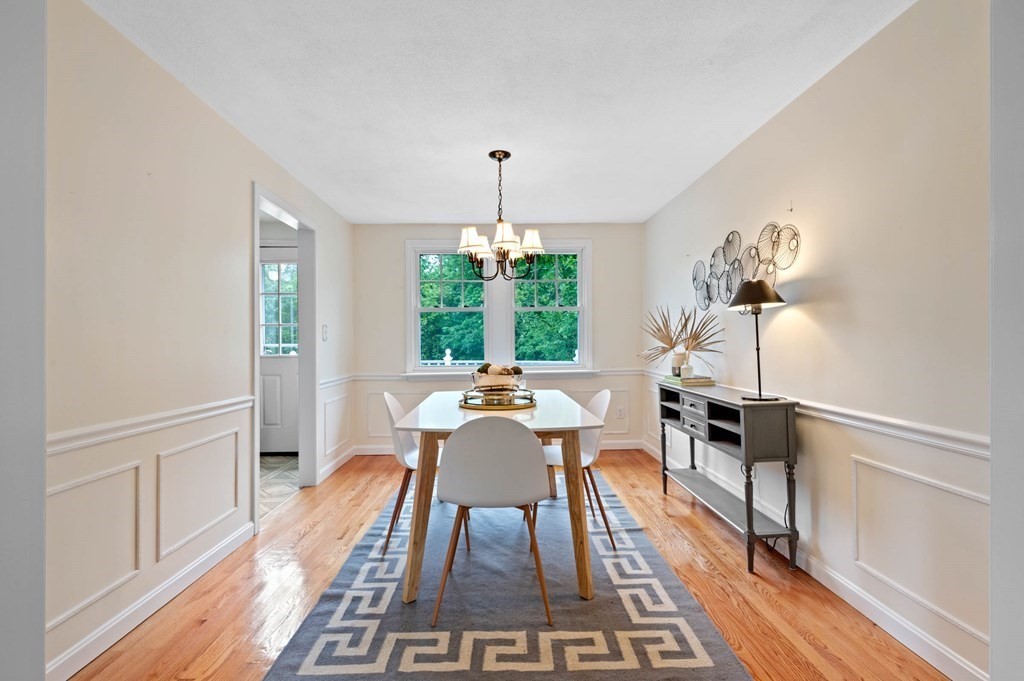 10 Wyman Road Billerica, MA 01821 - Photo 4 of 33 a dining room with wooden floor a chandelier a glass table and chairs