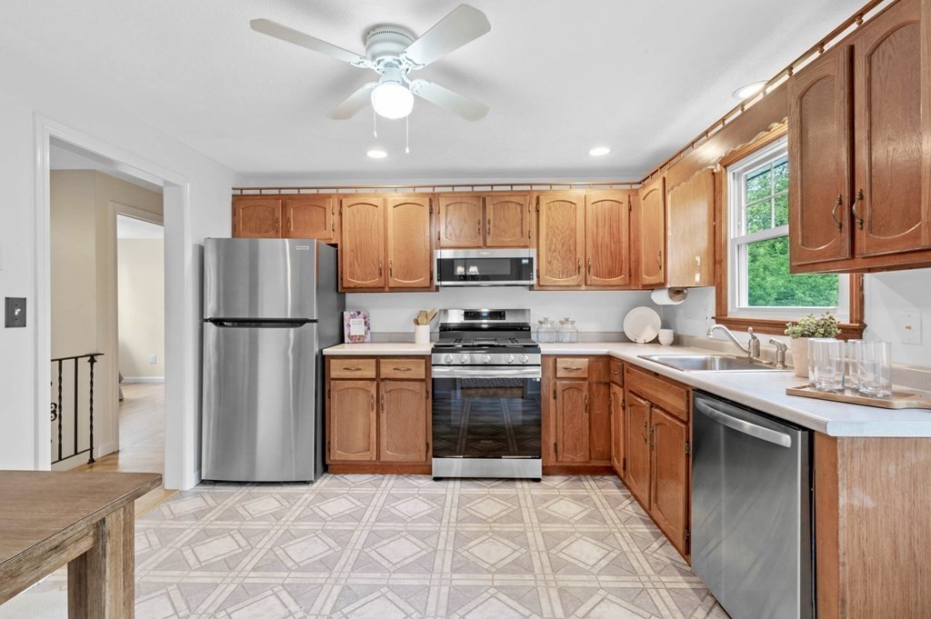 10 Wyman Road Billerica, MA 01821 - Photo 8 of 33 a kitchen with stainless steel appliances granite countertop a refrigerator a sink dishwasher a stove with wooden cabinets and floor
