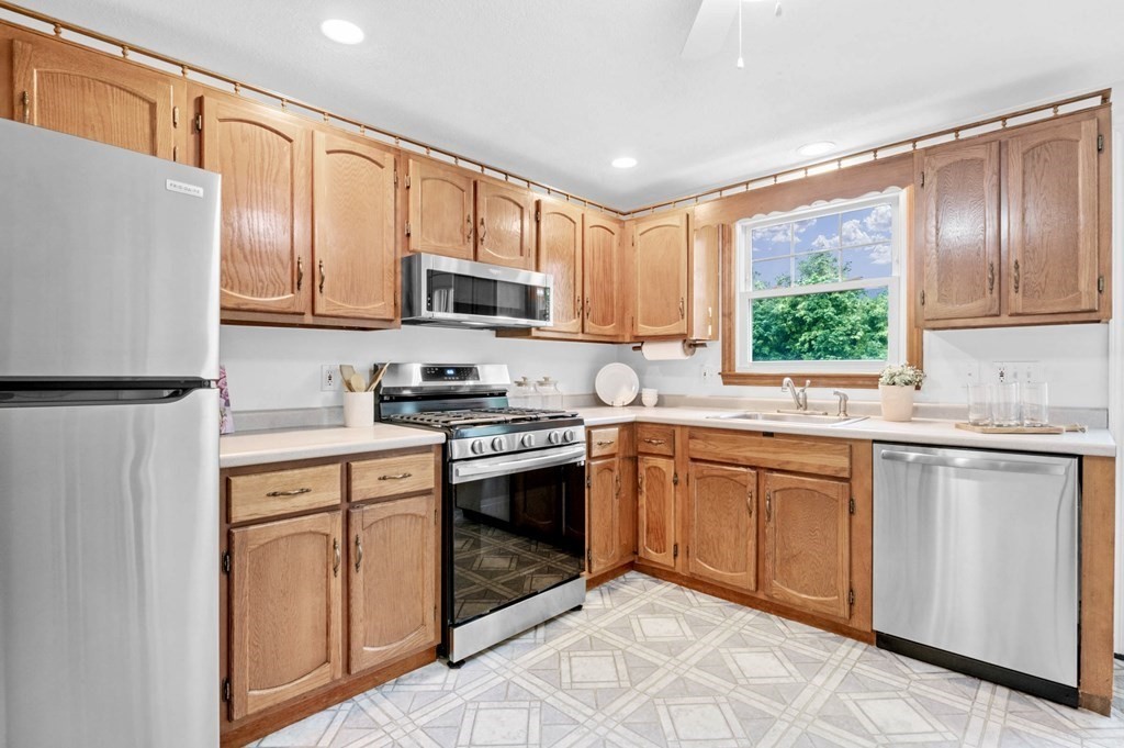 10 Wyman Road Billerica, MA 01821 - Photo 9 of 33 a kitchen with stainless steel appliances granite countertop a refrigerator a sink dishwasher a stove top oven a refrigerator with white cabinets and wooden floor