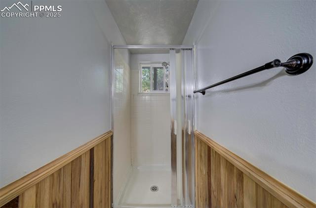 2768 Rigel Drive Colorado Springs, CO 80906 - Photo 25 of 44 Full bath featuring a wainscoted wall and a stall shower