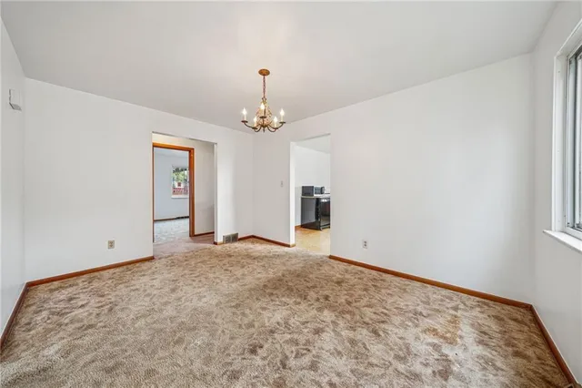 a view of an empty room and chandelier