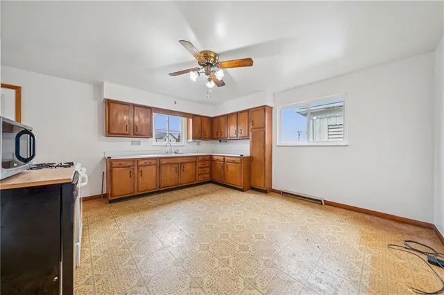 a view of a kitchen with a sink cabinets and a ceiling fan