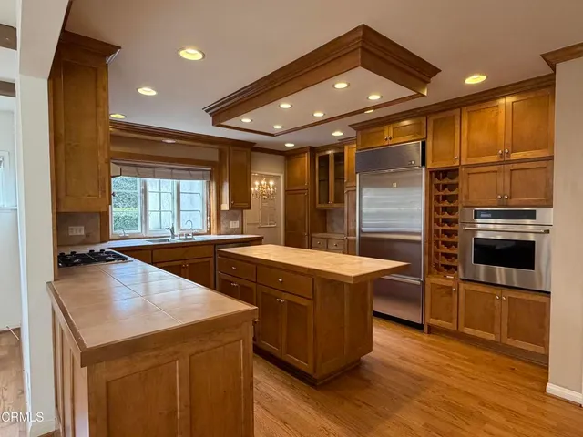 a kitchen with stainless steel appliances granite countertop a sink a stove and a refrigerator
