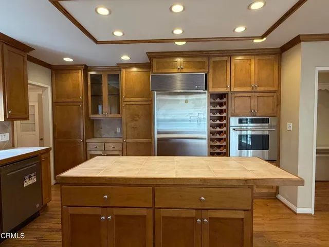 a kitchen with kitchen island a sink stainless steel appliances and cabinets