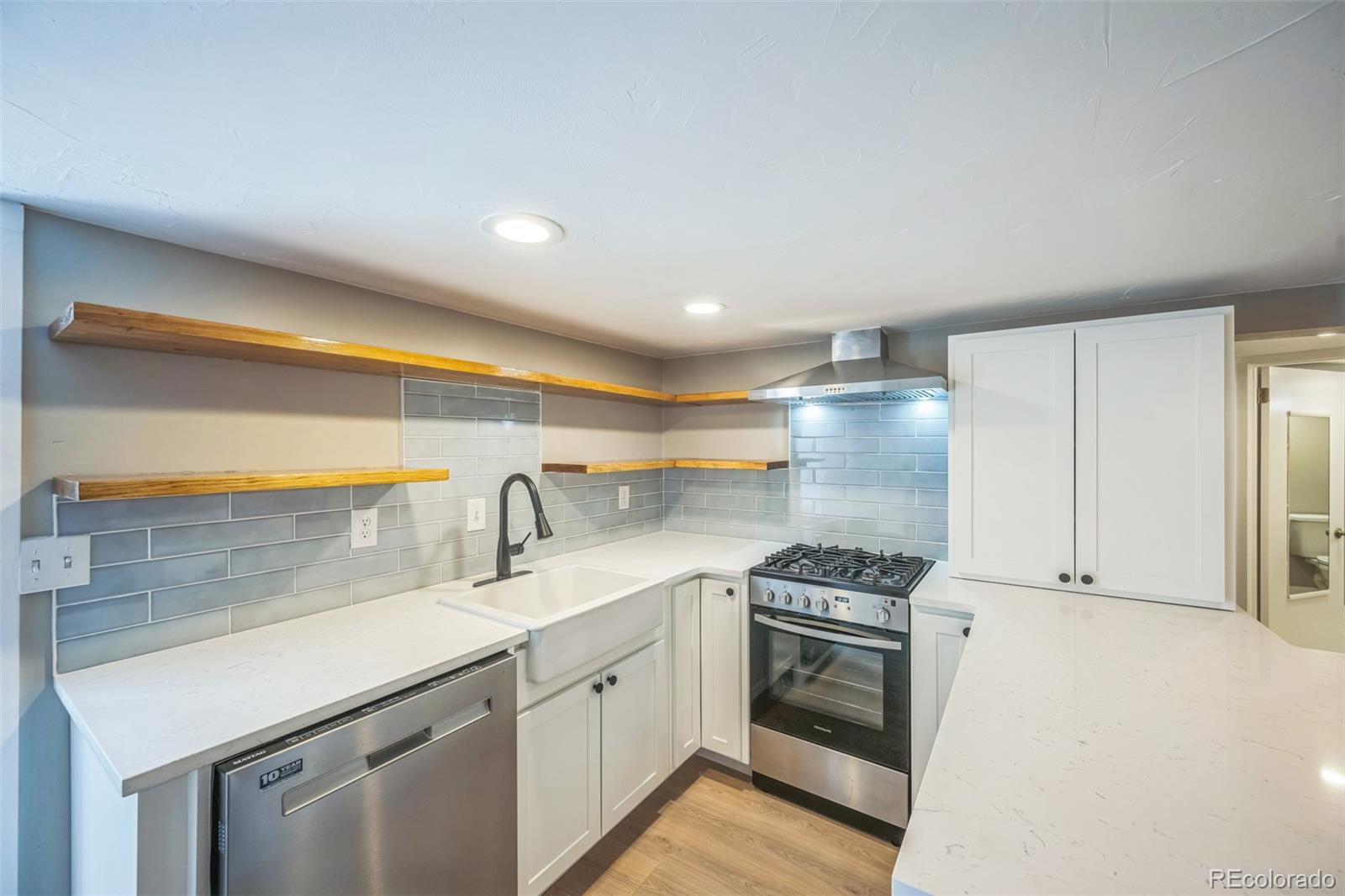 7340 West 32nd Avenue Wheat Ridge, CO 80033 - Photo 18 of 35 a kitchen with granite countertop a sink and a stove top oven