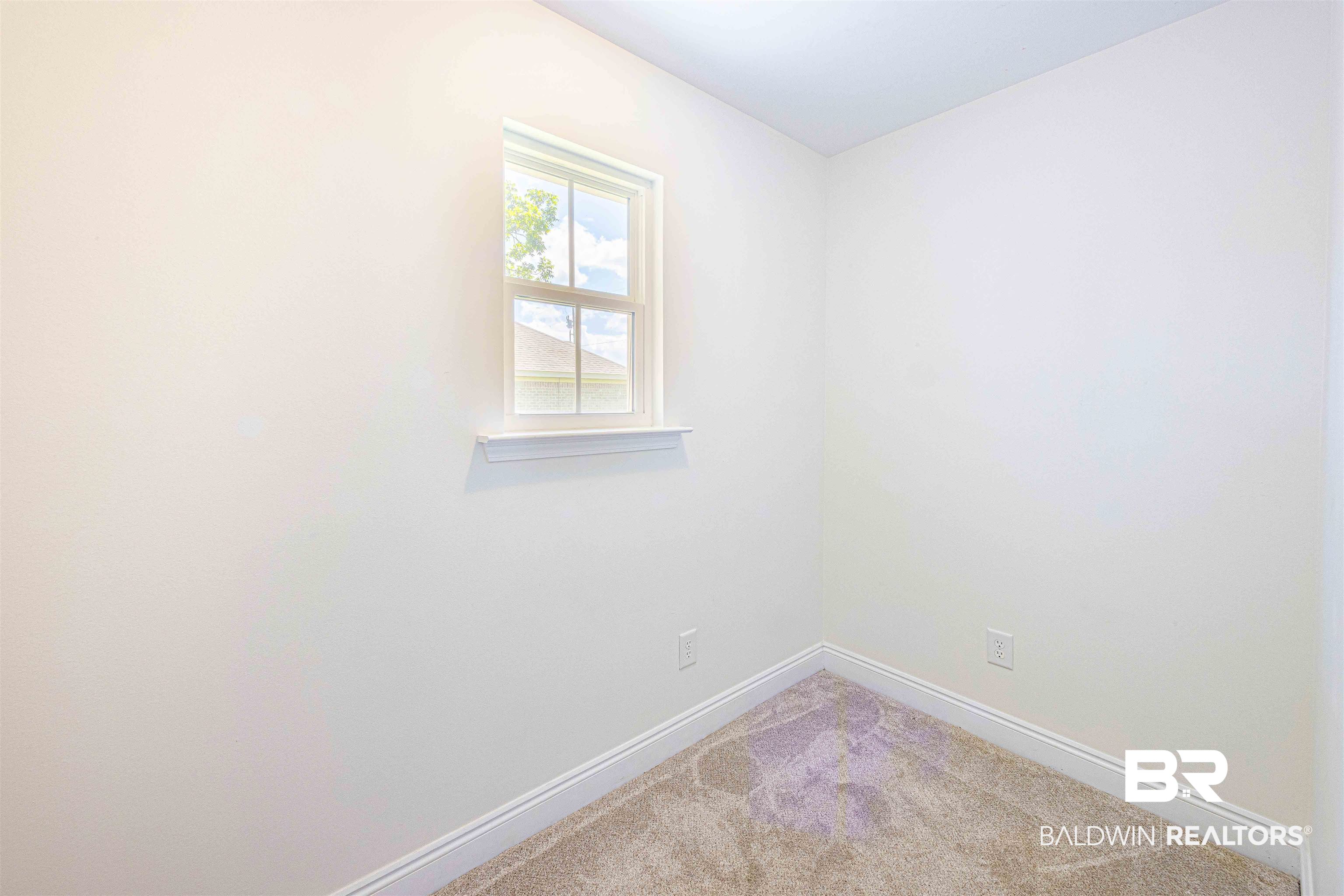 18675 Explorer Drive Loxley, AL 36551 - Photo 17 of 42 Spare room with baseboards and light colored carpet