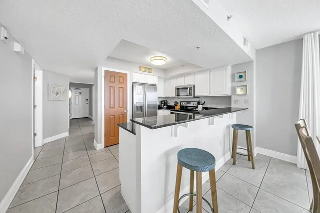 a kitchen with stainless steel appliances granite countertop a refrigerator and a stove top oven