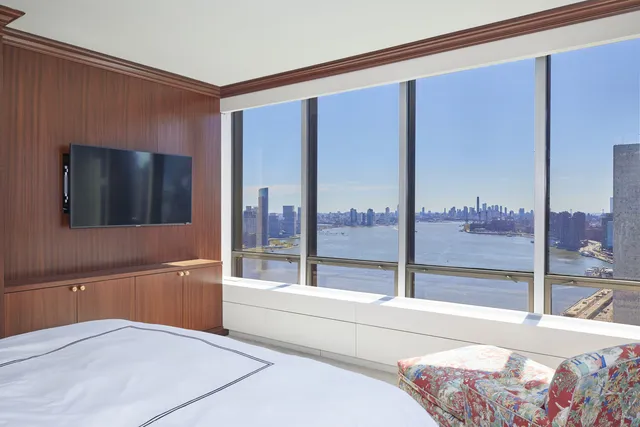 a bedroom with a large window and a flat screen tv