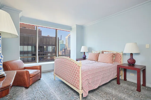 a bedroom with a bed and large window