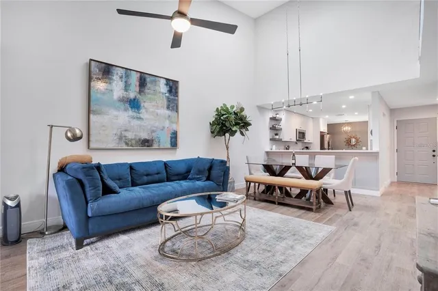 a living room with furniture kitchen view and a chandelier