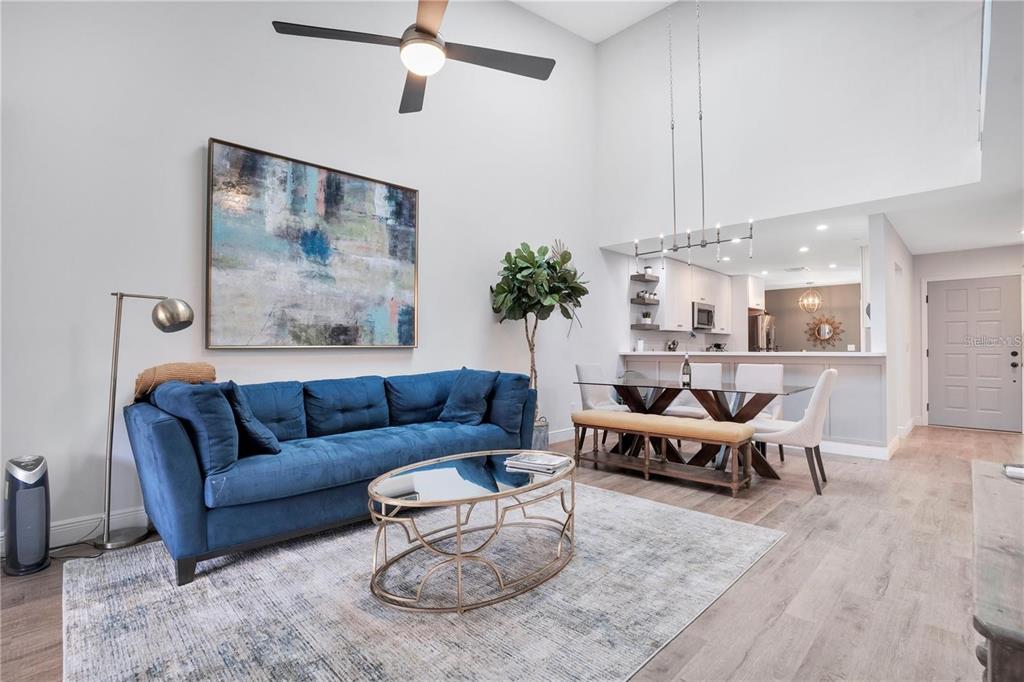 7736 Windbreak Road Orlando, FL 32819 - Photo 14 of 43 a living room with furniture kitchen view and a chandelier