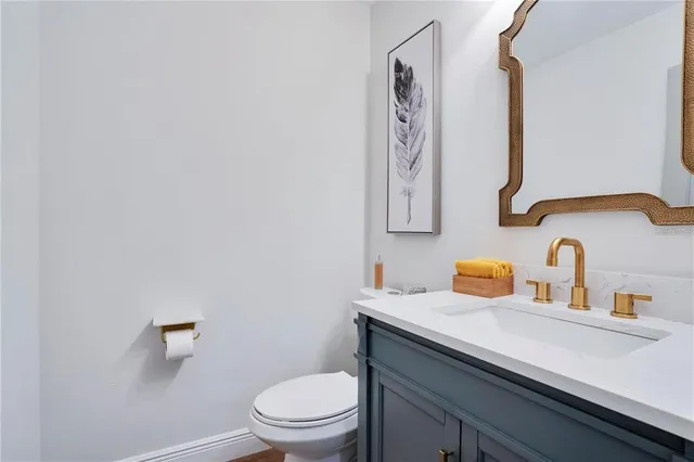 a bathroom with a toilet sink vanity and mirror