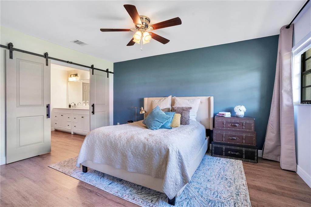 7736 Windbreak Road Orlando, FL 32819 - Photo 17 of 43 a bedroom with a bed and a chandelier