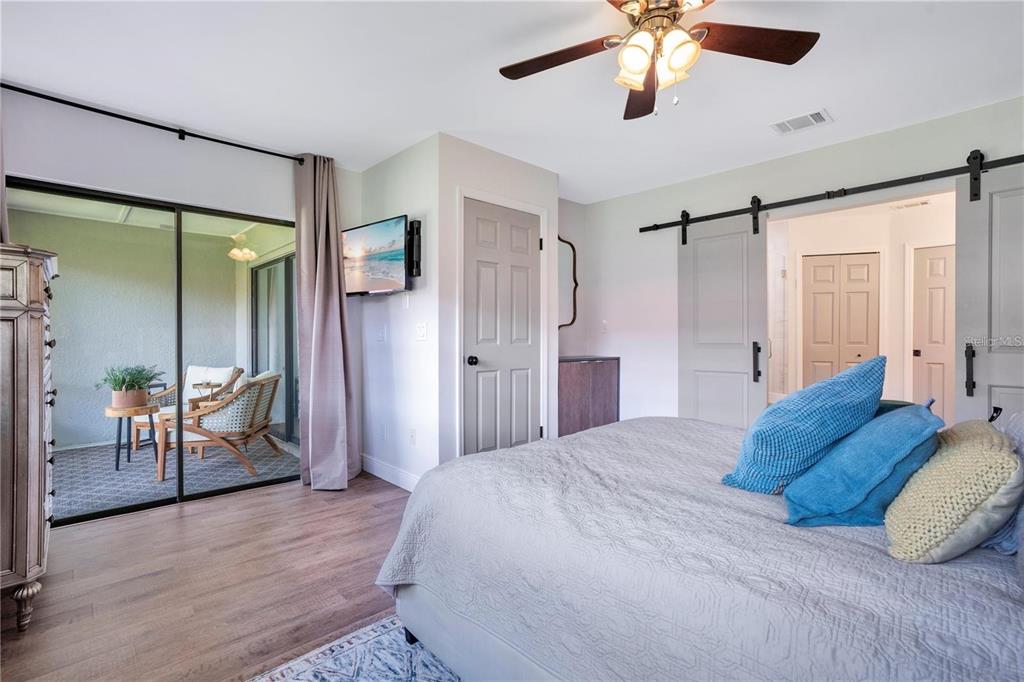 7736 Windbreak Road Orlando, FL 32819 - Photo 18 of 43 a spacious bedroom with a bed and a chandelier