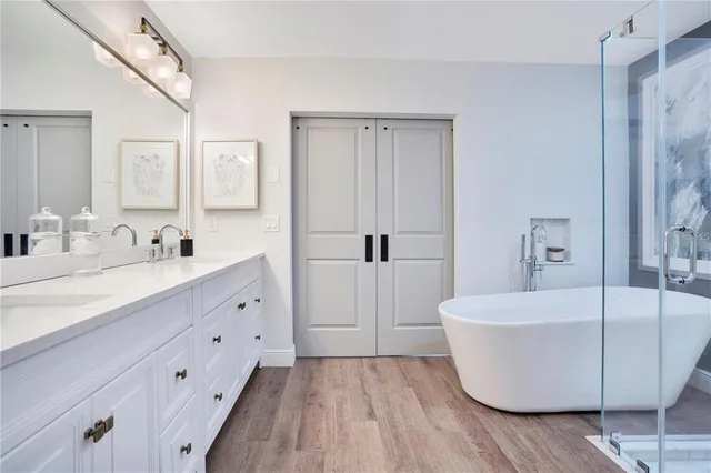 a spacious bathroom with a tub sink and mirror