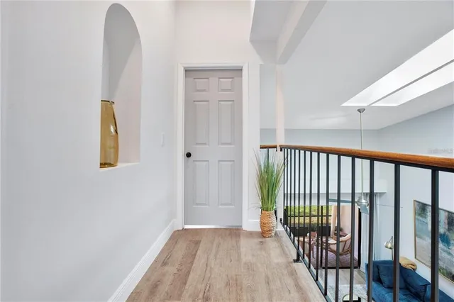 a view of a hallway with wooden floor and a potted plant
