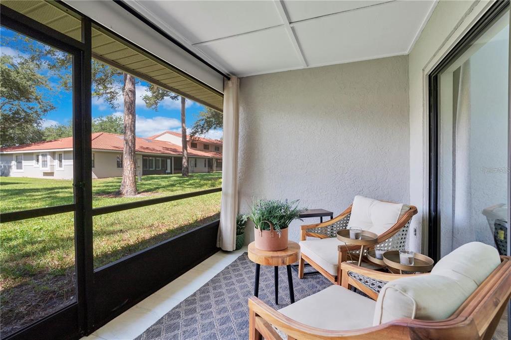 7736 Windbreak Road Orlando, FL 32819 - Photo 30 of 43 a living room with furniture and a floor to ceiling window