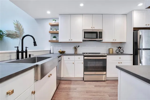 a kitchen with white cabinets and stainless steel appliances