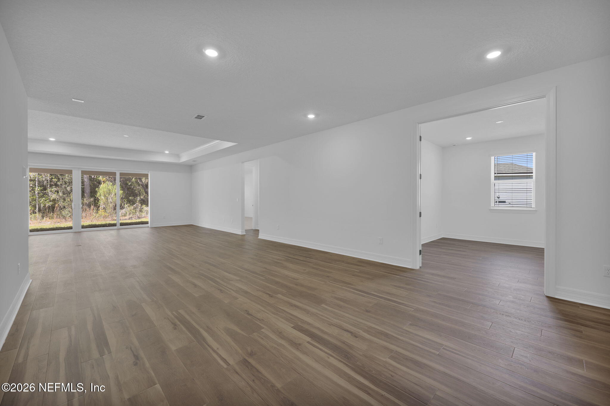 4896 Shell Crk Trail Jacksonville, FL 32226 - Photo 10 of 27 a view of an empty room with wooden floor and a window