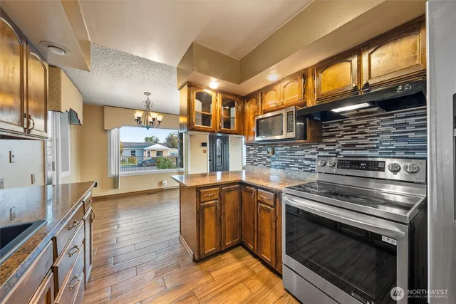 a kitchen with stainless steel appliances granite countertop a sink and a stove