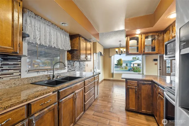 a kitchen with a granite countertop sink a stove and cabinets