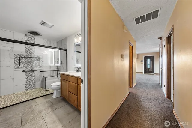 a bathroom with a granite countertop sink a toilet and shower