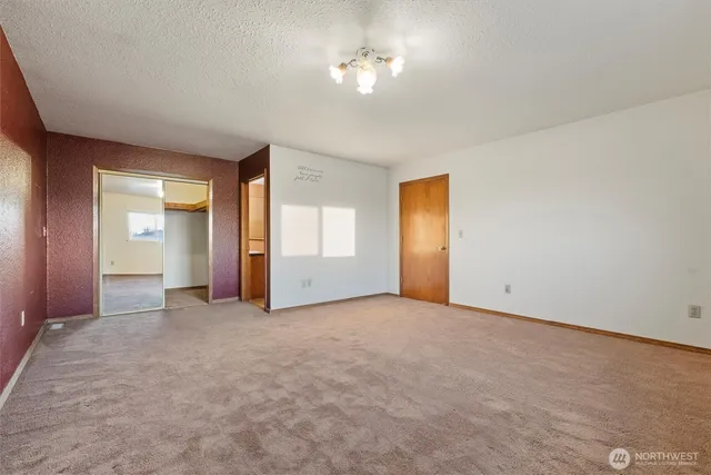 an empty room with windows and closet