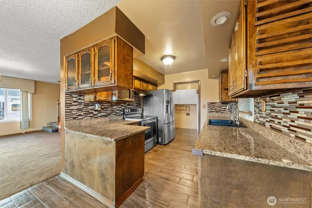 a kitchen with stainless steel appliances granite countertop a stove and a sink