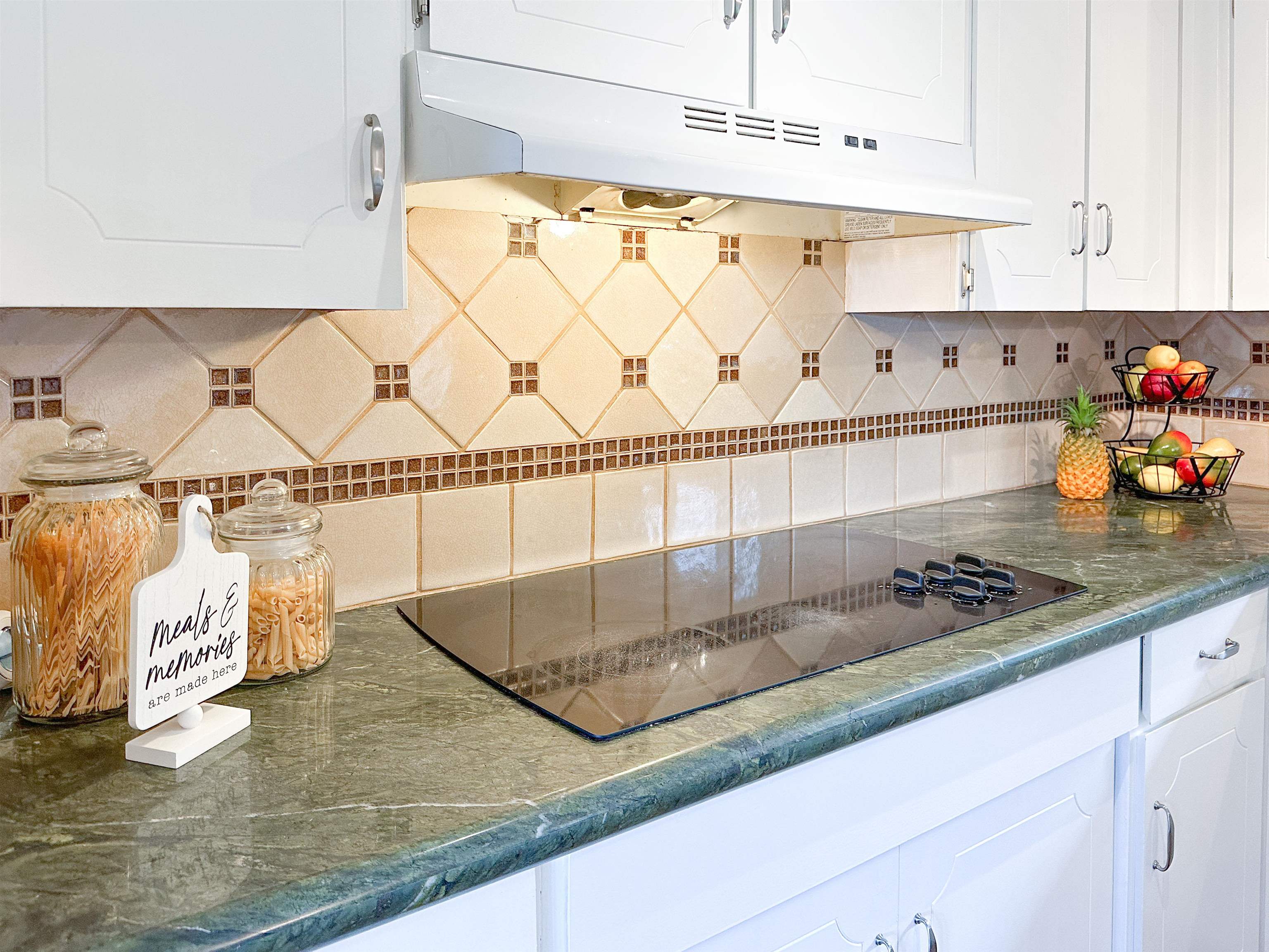 1875 Lower Kula Road Kula, HI 96790 - Photo 4 of 36 a kitchen with white cabinets and chandelier