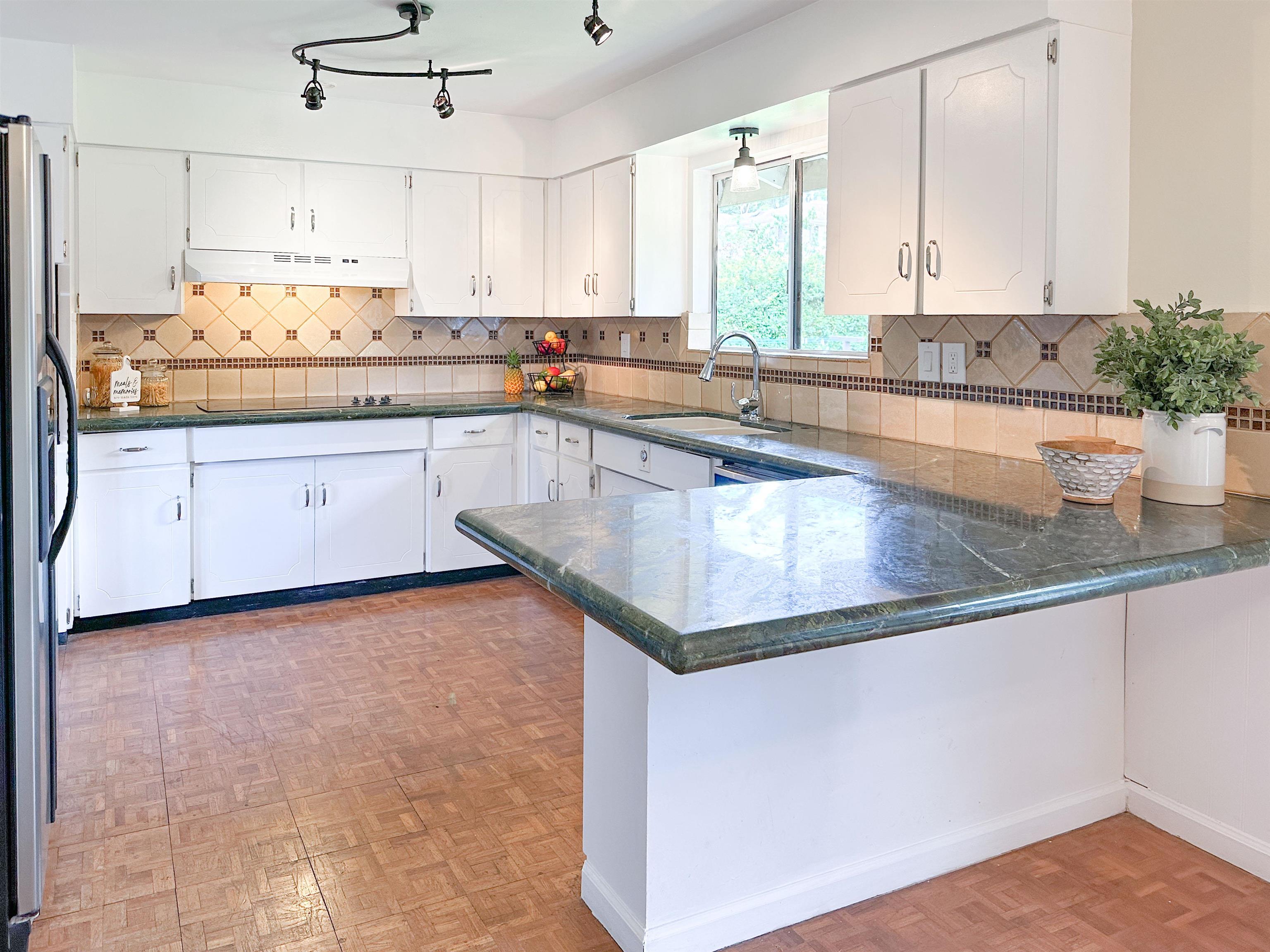 1875 Lower Kula Road Kula, HI 96790 - Photo 7 of 36 a kitchen with stainless steel appliances granite countertop a sink and white cabinets