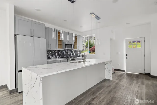 a view of kitchen with stainless steel appliances cabinets and wooden floor