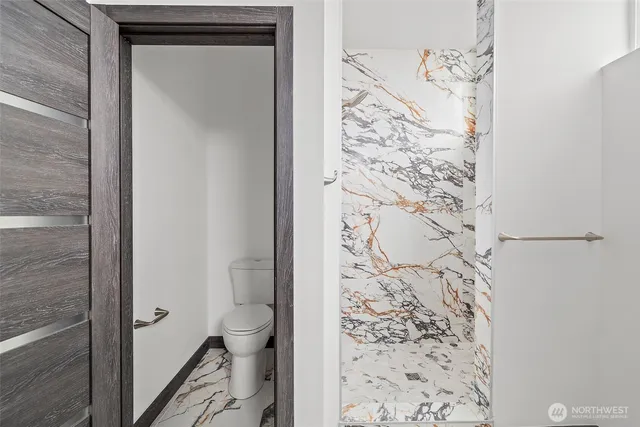 a bathroom with a toilet and a shower curtain