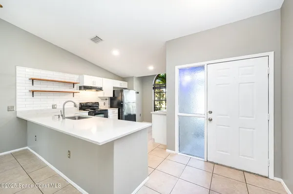 a kitchen with a sink a refrigerator and cabinets