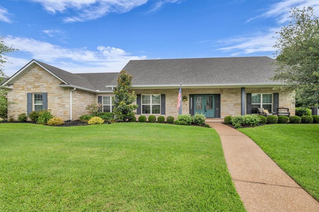 133 Creek Ridge Drive Waco, TX 76708 - Photo 1 of 1 View of front of house featuring stone siding, a shingled roof, a front yard, and a porch