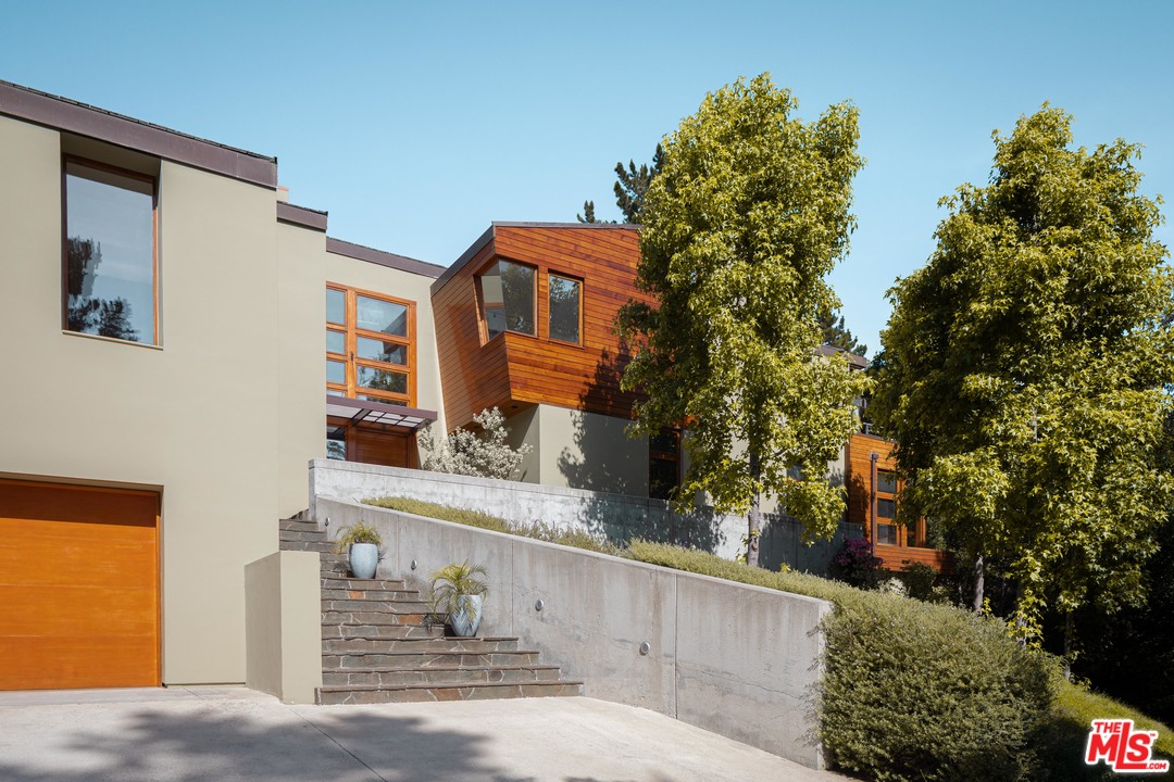 2244 Mandeville Canyon Road Los Angeles, CA 90049 - Photo 1 of 50 a front view of a house with trees