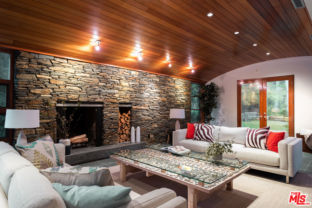 2244 Mandeville Canyon Road Los Angeles, CA 90049 - Photo 12 of 50 a living room with furniture and a fireplace