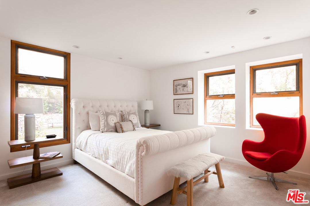 2244 Mandeville Canyon Road Los Angeles, CA 90049 - Photo 23 of 50 a bedroom with a bed chair and a large window