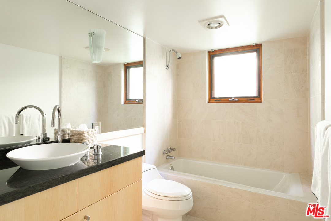 2244 Mandeville Canyon Road Los Angeles, CA 90049 - Photo 24 of 50 a bathroom with a granite countertop sink toilet and shower