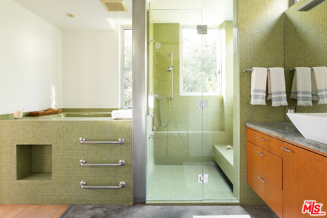 2244 Mandeville Canyon Road Los Angeles, CA 90049 - Photo 28 of 50 a bathroom with a shower a mirror and a sink