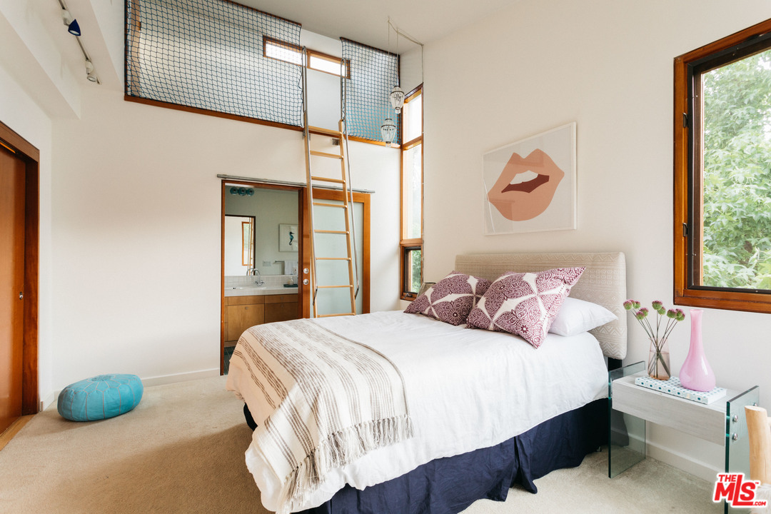 2244 Mandeville Canyon Road Los Angeles, CA 90049 - Photo 41 of 50 a bedroom with a bed and window