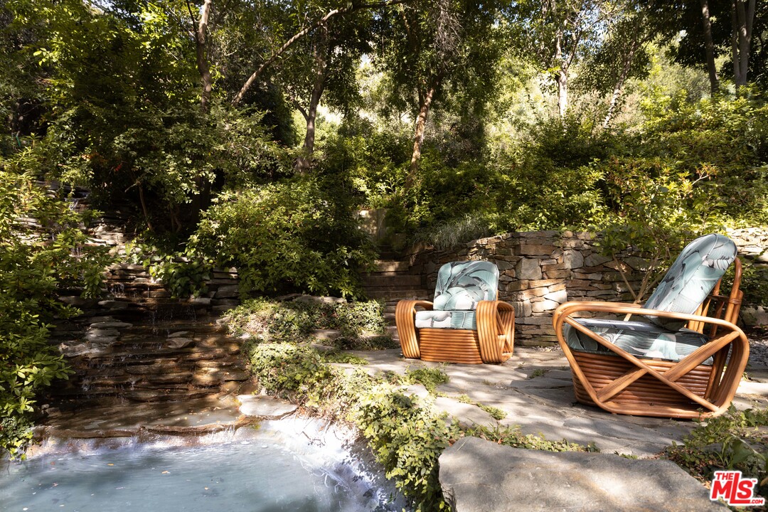 2244 Mandeville Canyon Road Los Angeles, CA 90049 - Photo 46 of 50 a backyard of a house with table and chairs