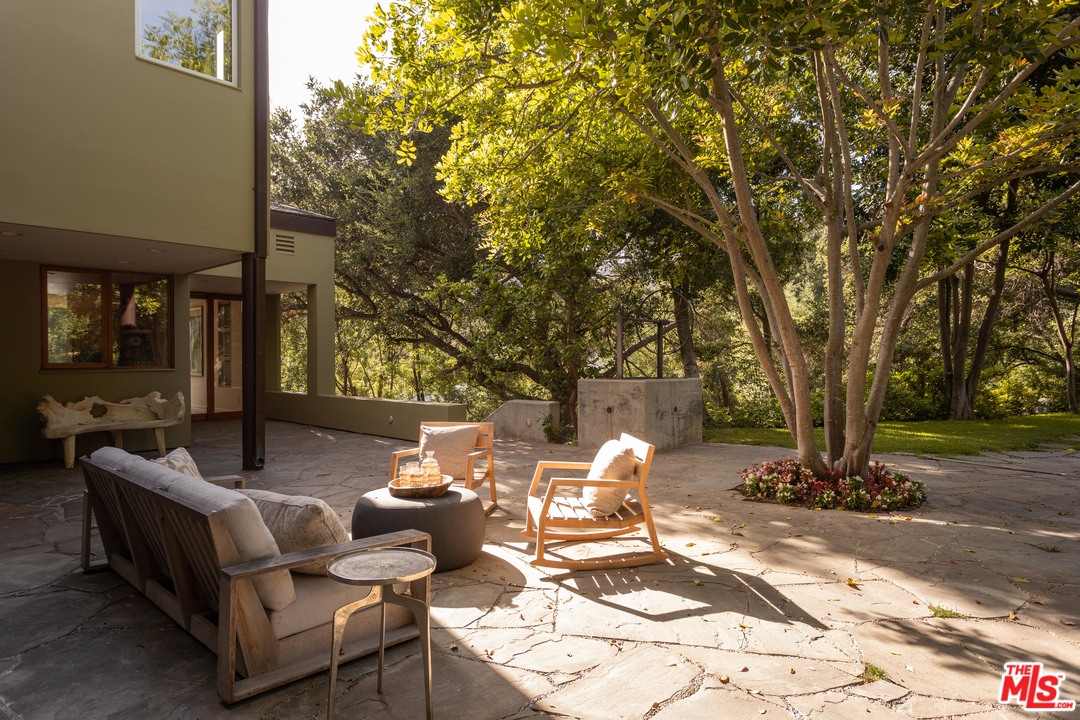 2244 Mandeville Canyon Road Los Angeles, CA 90049 - Photo 47 of 50 a view of a patio with table and chairs and potted plants