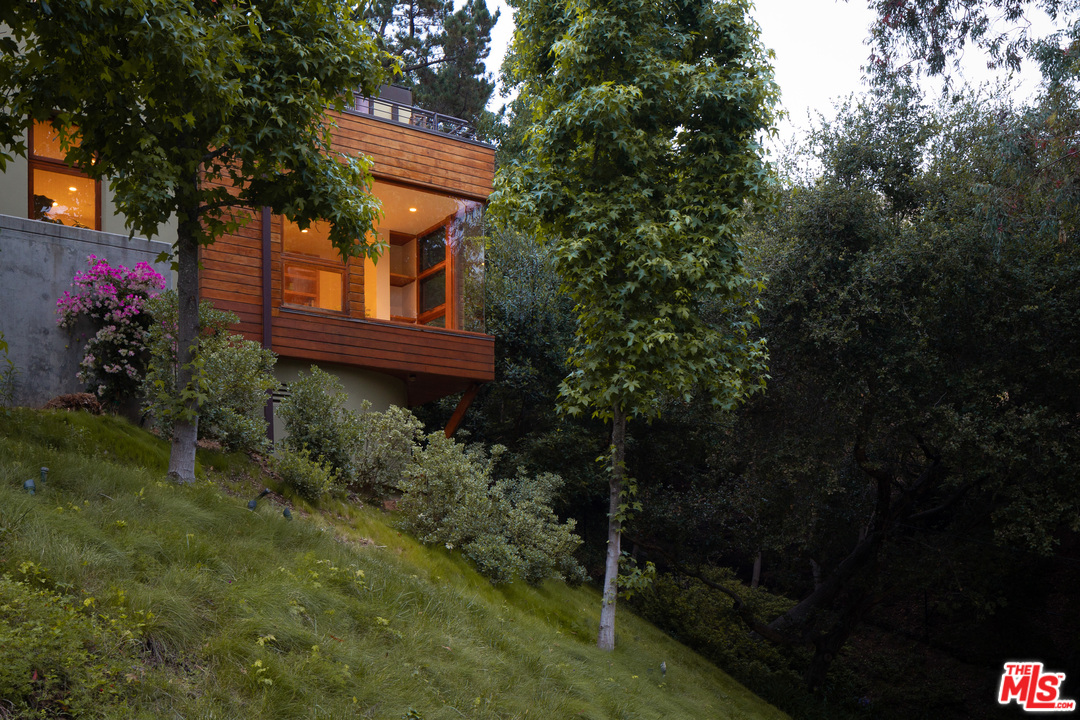 2244 Mandeville Canyon Road Los Angeles, CA 90049 - Photo 49 of 50 a view of a house with a yard