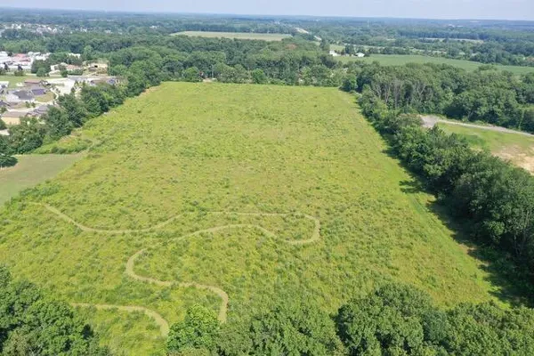 an aerial view of residential houses with outdoor space and trees