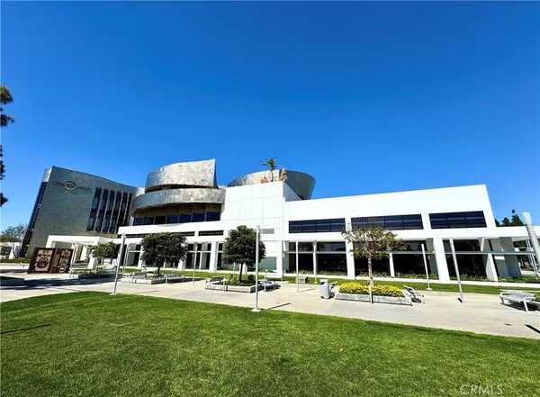 a backyard of a house with table and chairs under an umbrella