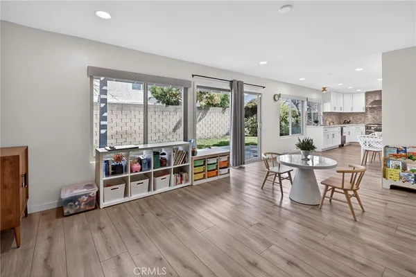 a kitchen with stainless steel appliances kitchen island granite countertop a table chairs stove microwave and cabinets with wooden floor