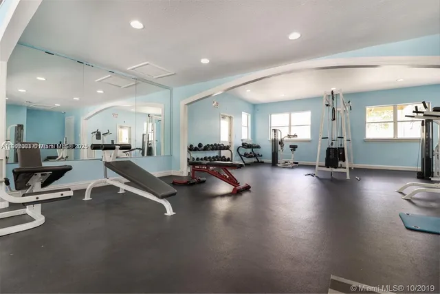 a room with lots of table chairs and a large window