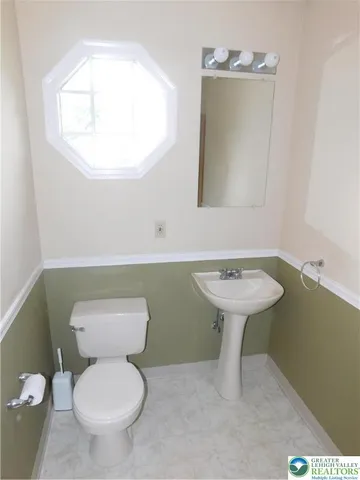 a bathroom with a toilet sink and mirror